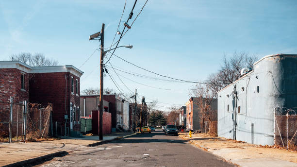 A quiet urban neighborhood street with row houses and utility lines