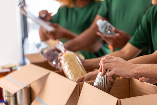 Volunteers packing canned food and pasta into donation boxes